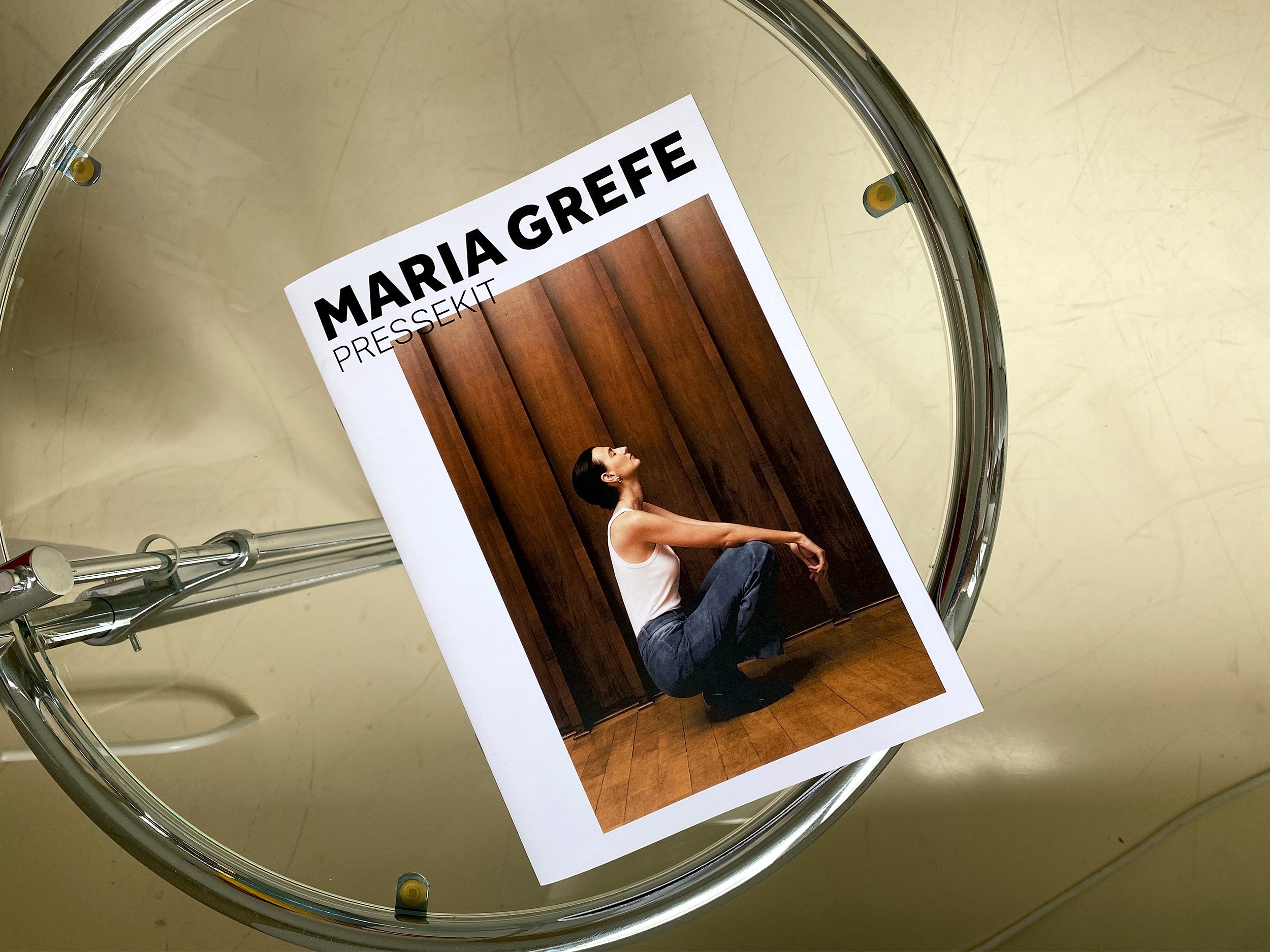 MARIA GREFE Press Kit platziert auf einem Glastisch
